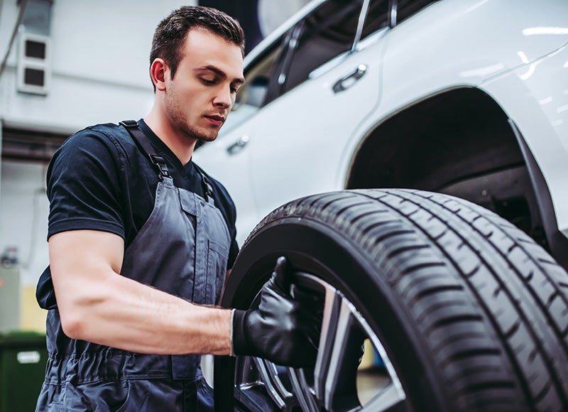 Mechanic putting tire on car