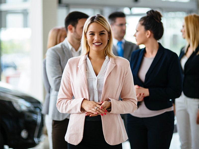 A women stands front of Team members